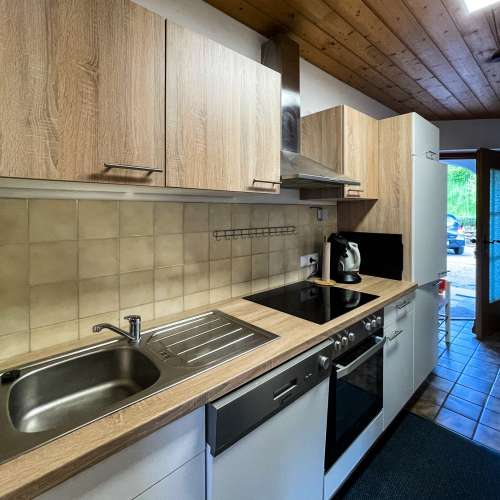 Voll ausgestattete Küche mit Herd, Mikrovelle, Kühlschrank, Geschirrspüler